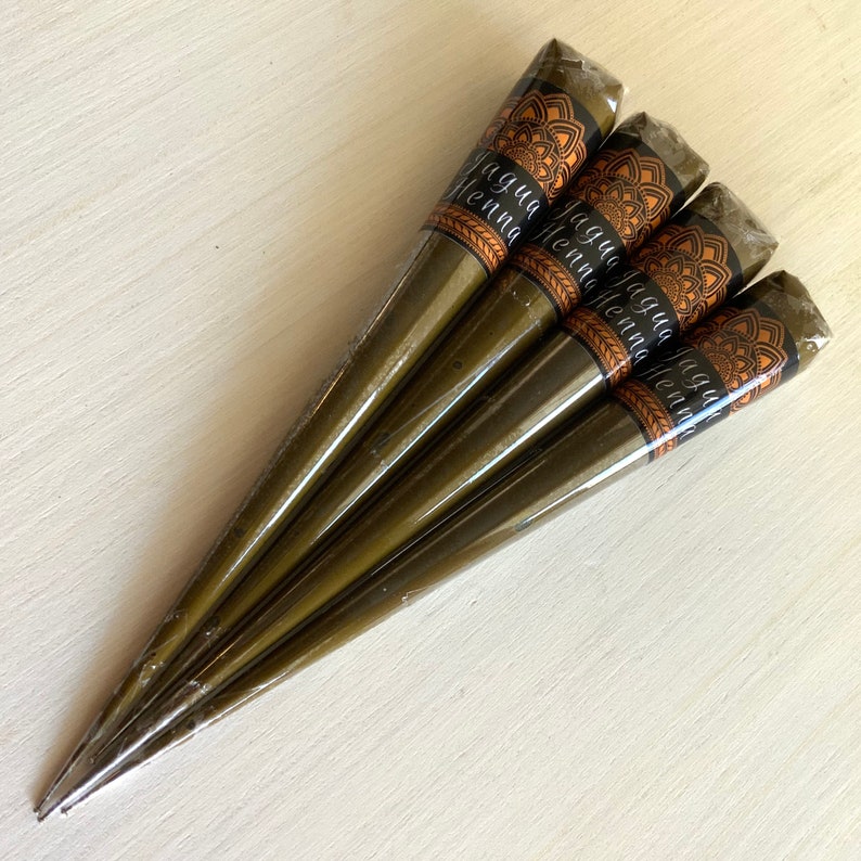 May include: Five brown henna cones with a black and gold label that reads "Jagua Henna".