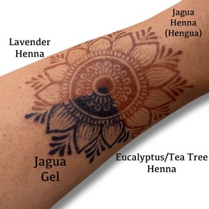 May include: A close-up of a person's arm with a henna design. The design is split in half, with one side done with Jagua Gel and the other side done with Eucalyptus/Tea Tree Henna. The text "Jagua Gel" is written below the Jagua side of the design, and the text "Eucalyptus/Tea Tree Henna" is written below the Eucalyptus/Tea Tree Henna side of the design. The text "Lavender Henna" is written above the design, and the text "Jagua Henna (Hengua)" is written above the design.