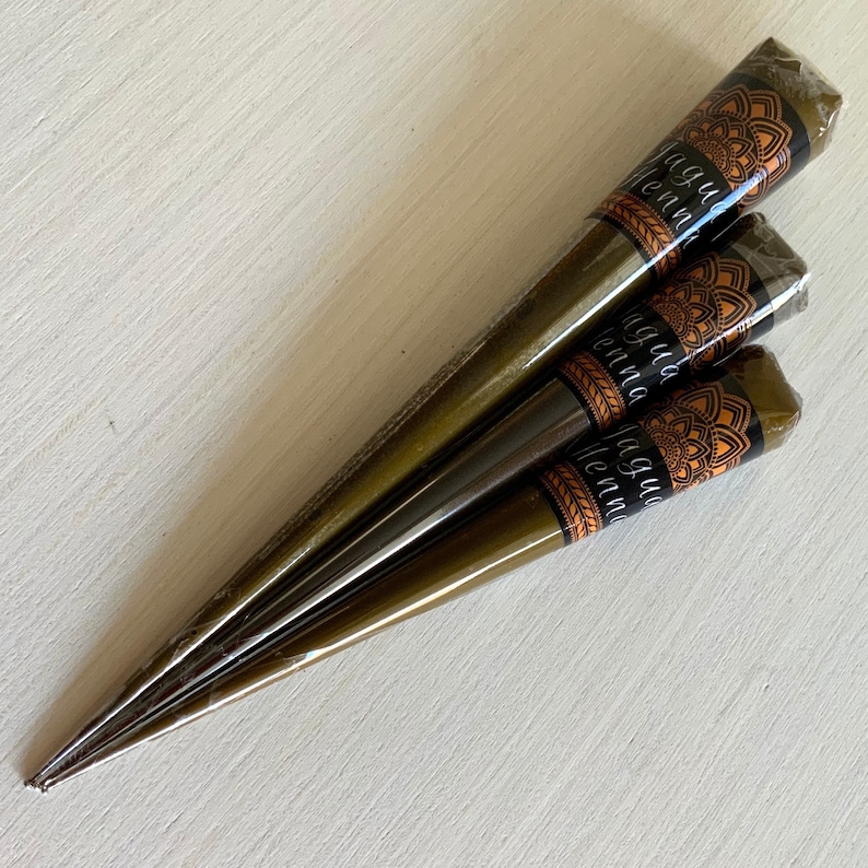 May include: Three brown henna cones with gold and orange labels that say "Jagua Henna".