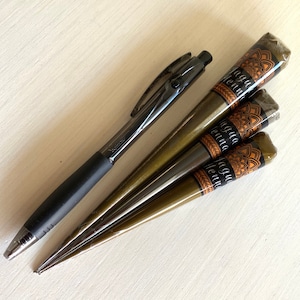May include: Four brown henna cones with black and gold labels that say "Jagua Henna" and a black pen.