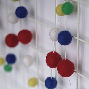 Wool felt ball garland in red, white, blue green and yellow.
