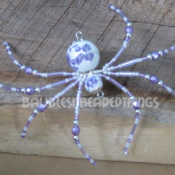 Araña navideña con cuentas de flores moradas y blancas
