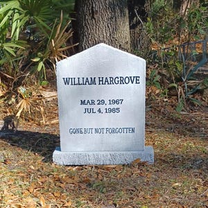 Peut inclure: Une pierre tombale grise avec le nom "WILLIAM HARGROVE" inscrit en noir. Les dates "MAR 29, 1967" et "JUL 4, 1985" sont en dessous, avec la phrase "GONE BUT NOT FORGOTTEN" en bas. La pierre tombale est dans un espace herbeux.