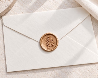 May include: A rectangular off-white envelope featuring a circular metallic gold wax seal centered on the flap. The wax seal is embossed with a detailed botanical sprig design, showcasing a central stem with multiple small, pointed leaves.