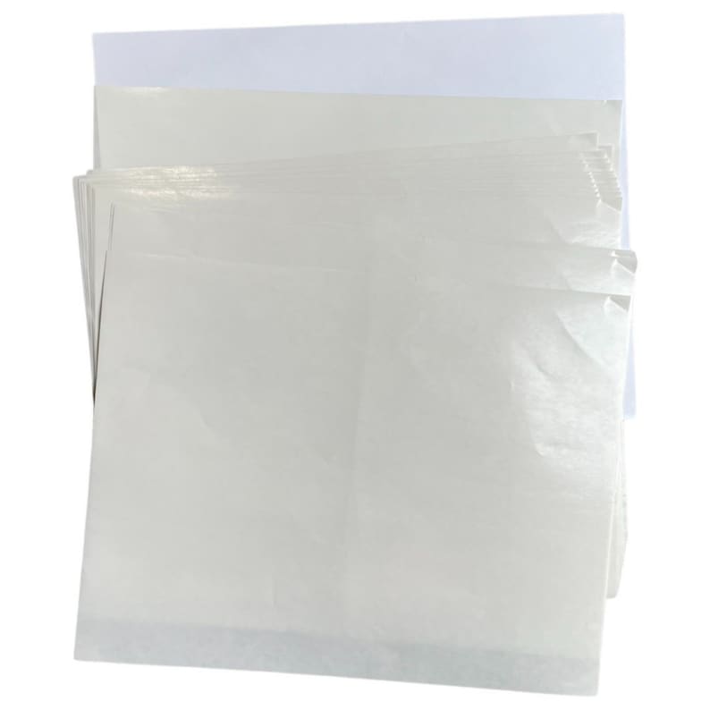 Pode incluir: Uma pilha de folhas de papel brancas, em branco, com suporte adesivo. As folhas est&atilde;o ligeiramente enrugadas e t&ecirc;m um acabamento liso e brilhante.