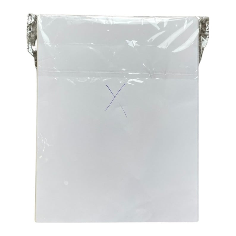 Pode incluir: Uma folha de papel branca em uma manga de pl&aacute;stico transparente. O papel tem uma marca de tinta azul em forma de 'X'.