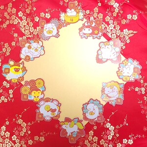 May include: Twelve colorful stickers featuring the Chinese zodiac animals. Each sticker has a cartoon animal with a Chinese character and the English translation of the animal's name. The stickers are on a red background with gold floral patterns.