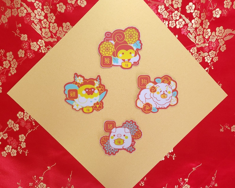 May include: Four colorful stickers featuring Chinese zodiac animals. Each sticker has a red background with gold accents and features a cartoon animal with a Chinese character for the animal's name. The animals are a monkey, a rooster, a dog, and a pig.