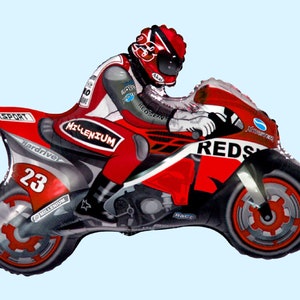 May include: Red and black inflatable motorcycle with a rider wearing a red and white racing suit. The motorcycle has the word "REDS" on the side and the number "23" on the back wheel.