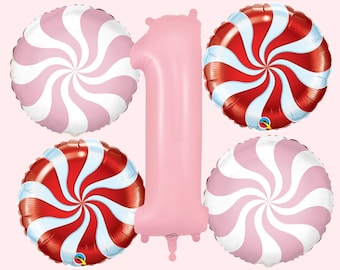May include: A set of pink and red swirl candy-themed balloons, including a large pink number one balloon.