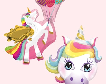 May include: Two unicorn foil balloons. One balloon is a pink unicorn with rainbow mane and tail, gold wings, and a star on its side. The other balloon is a unicorn face with a rainbow mane and a white horn.