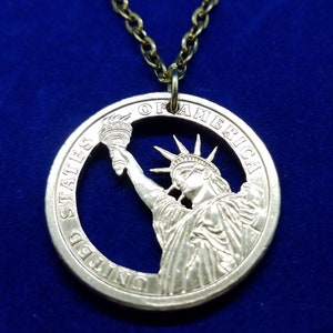Hand cut presidential dollar coin showing off Lady Liberty with coin case 