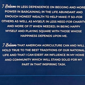 May include: A blue background with white text that reads "7 Believe IN LESS DEPENDENCE ON BEGGING AND MORE POWER IN BARGAINING; IN THE LIFE ABUNDANT AND ENOUGH HONEST WEALTH TO HELP MAKE IT SO-FOR OTHERS AS WELL AS MYSELF; IN LESS NEED FOR CHARITY AND MORE OF IT WHEN NEEDED; IN BEING HAPPY MYSELF AND PLAYING SQUARE WITH THOSE WHOSE HAPPINESS DEPENDS UPON ME. 7 Believe THAT AMERICAN AGRICULTURE CAN AND WILL HOLD TRUE TO THE BEST TRADITIONS OF OUR NATIONAL LIFE AND THAT I CAN EXERT AN INFLUENCE IN MY HOME AND COMMUNITY WHICH WILL STAND SOLID FOR MY PART IN THAT INSPIRING TASK."