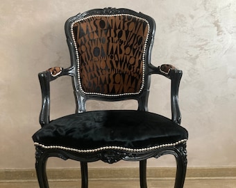 Poltrona vintage in pelle di mucca: struttura nera intagliata, finiture in argento