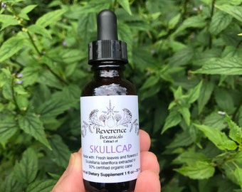 May include: A brown glass bottle with a black dropper top, labeled "Reverence Botanicals Extract of SKULLCAP Made with Fresh leaves and flowers of Scutellaria lateriflora extracted in 50% certified organic cane Herbal Dietary Supplement 1 fl oz - 30 ml"