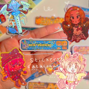 May include: A collection of colorful stickers featuring cartoon characters and designs. One sticker reads "RabbitSP" in blue and yellow. The image also includes the text "Stickers catalogue".