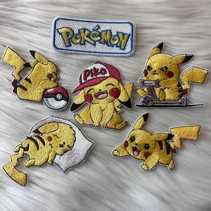 May include: Embroidered patches featuring Pikachu from Pokémon. The patches include Pikachu with a Pokéball, wearing a hat, riding a scooter, and in other poses. A rectangular patch with the Pokémon logo is also included. The patches are yellow, red, black, and white.