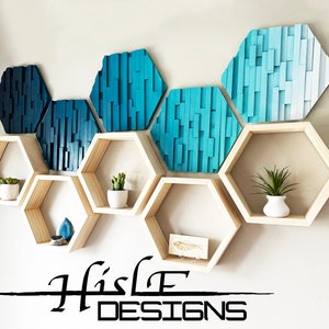 May include: A set of six hexagonal wooden shelves with a blue and white geometric wall art piece behind them. The shelves are arranged in a staggered pattern and feature small plants and decorative items. The wall art is made of wood and has a gradient of blue shades.