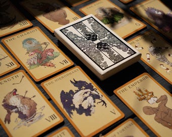 May include: A spread of tarot cards with illustrations of various characters and symbols. The cards are laid out on a dark surface. The cards include The Chariot, Strength, The Hierophant, The Emperor, and The Magician.
