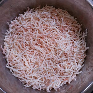 May include: A bowl filled with thin, white and pink strands of dried seaweed.