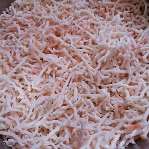 May include: A close-up of a bowl filled with white and pink coral branches. The coral is dried and has a delicate, brittle texture.