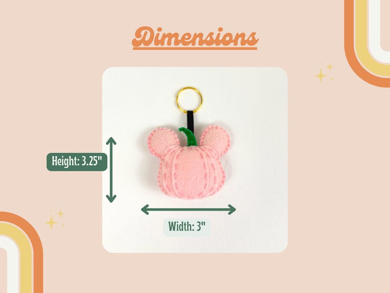 May include: A pink felt pumpkin keychain with a green stem and gold key ring. The keychain measures 3.25 inches in height and 3 inches in width.