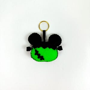 May include: Green felt Frankenstein keychain with black felt ears and a gold key ring.