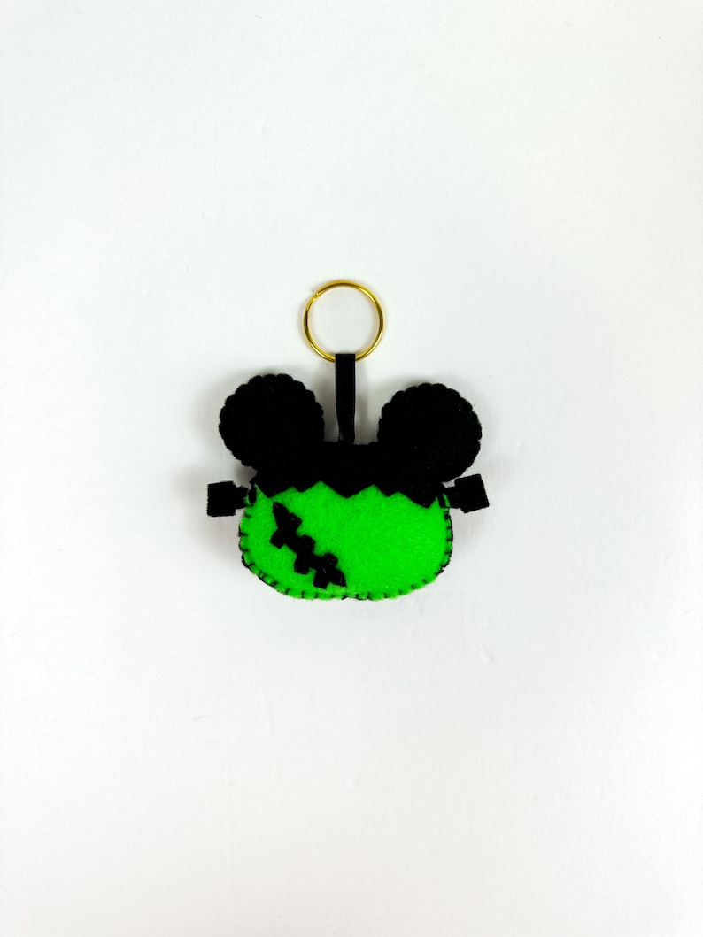 May include: Green felt Frankenstein keychain with black felt ears and a gold key ring.
