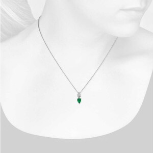 May include: A delicate silver necklace featuring a pear-shaped, emerald-green gemstone pendant. The pendant is accented with a small, round, clear stone above it. The necklace is displayed against a white background.