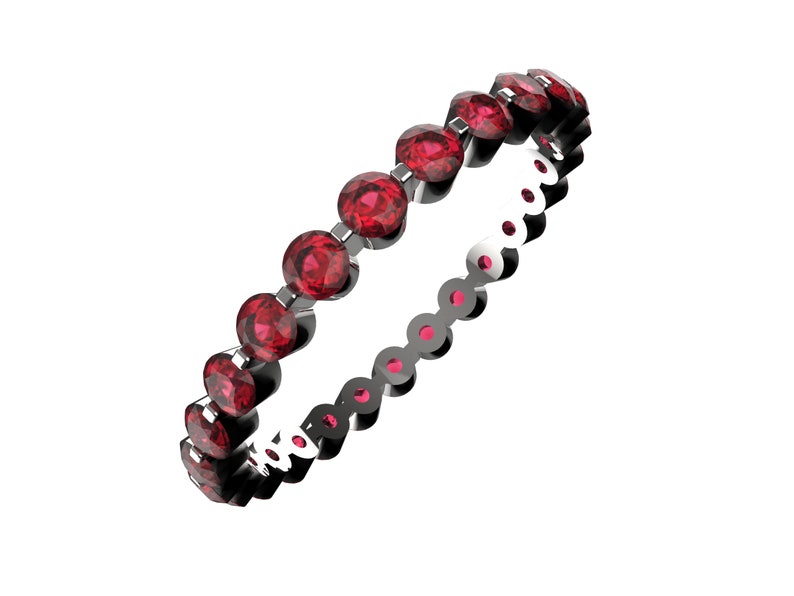 K&ouml;nnte beinhalten: Ein zarter Ewigkeitsring mit einer Reihe runder roter Edelsteine, die in eine silberne Band gefasst sind.