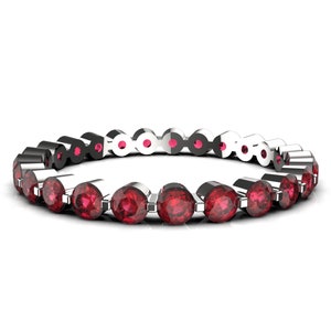 K&ouml;nnte beinhalten: Ein silberner Ewigkeitsring mit einer Reihe runder roter Edelsteine.