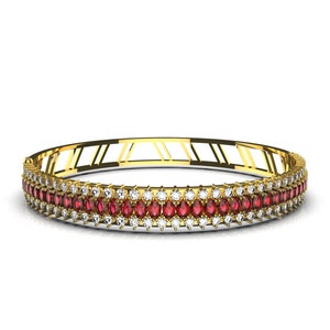 May include: A gold bangle bracelet with a double row of red and white gemstones.