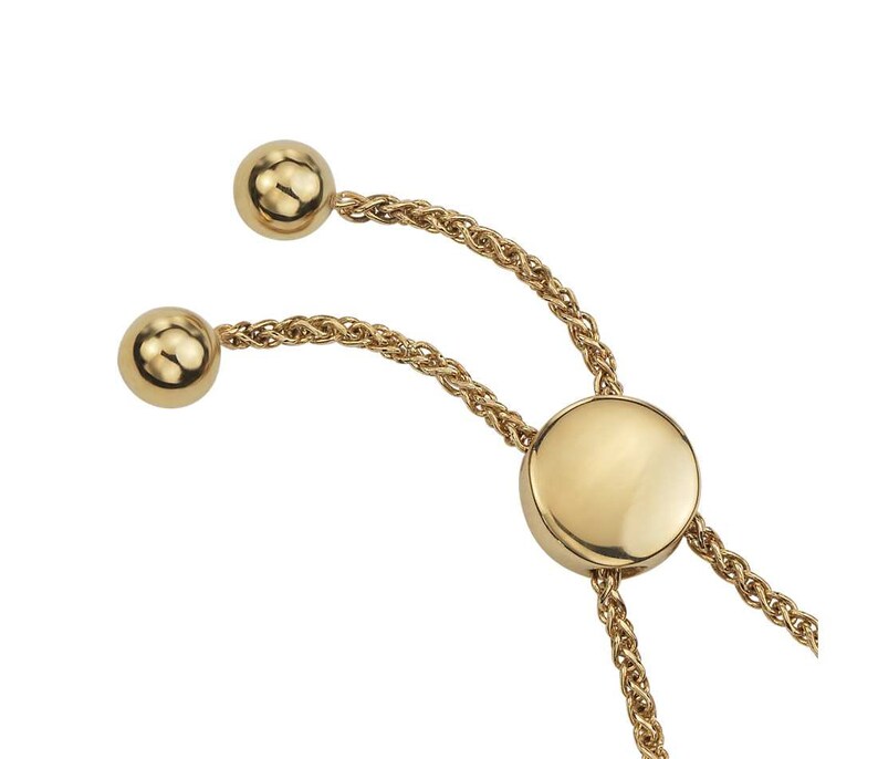 May include: A gold chain bracelet with a round, flat charm and two round beads at the ends. The chain is a rope style.