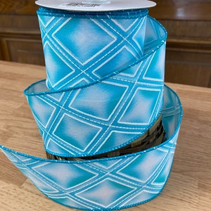 May include: A roll of blue and white patterned ribbon with a diamond design. The ribbon is 2.5 inches wide and has a wired edge.