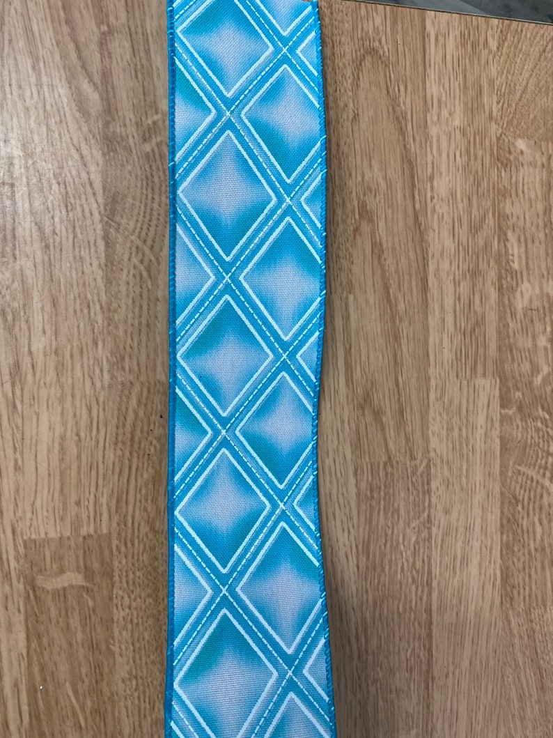 May include: A blue and white ribbon with a diamond pattern. The ribbon has a light blue background with white diamonds.
