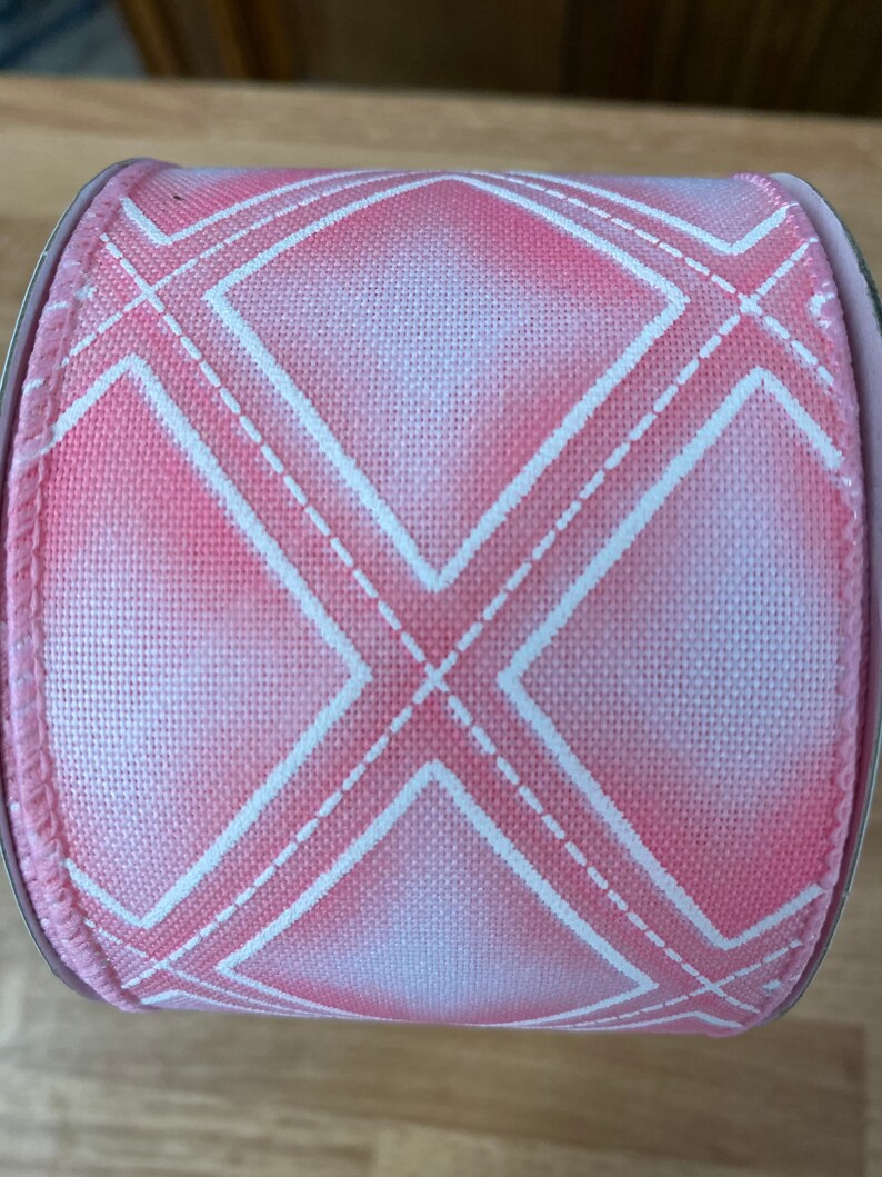 May include: Pink and white ribbon with a diamond pattern. The ribbon is made of a soft, textured fabric and has a subtle ombre effect.
