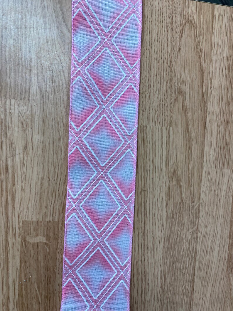 May include: Pink and white ribbon with a diamond pattern.