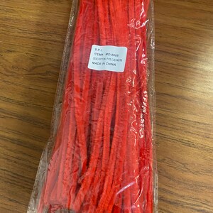 Puede incluir: Una bolsa de limpiapipas rojos. La bolsa tiene una etiqueta que dice "S.P.I. ITEM# MD-9005 DESCRIPTION: PIPE CLEANERS MADE IN CHINA."
