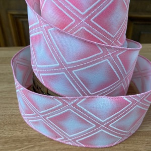 May include: Pink and white ribbon with a diamond pattern. The ribbon is made of a soft, textured fabric and has a subtle sheen.