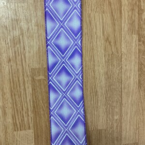 May include: Purple ribbon with a white diamond pattern. The ribbon has a satin finish.