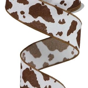 May include: Brown and white cow print ribbon with a brown edge. The ribbon is 2.5 inches wide.