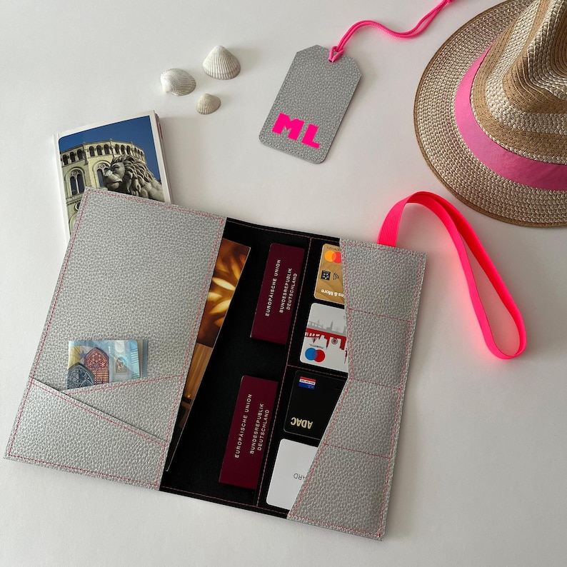 Das silberne Reiseetui mit Neon-Akzenten aus reißfestem Papier mit geprägter Leder-Optik ist die ideale Lösung, um Reisedokumente sicher und stilvoll aufzubewahren. Die Reisedokumententasche bietet ausreichend Platz für Pässe, Kreditkarten und vieles mehr. Ein perfektes Geschenk für Weltreisende.