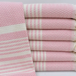 May include: A stack of pink and white striped towels with fringe edges. The towels are made of cotton and are soft and absorbent.