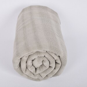 May include: A rolled up gray waffle weave throw blanket.