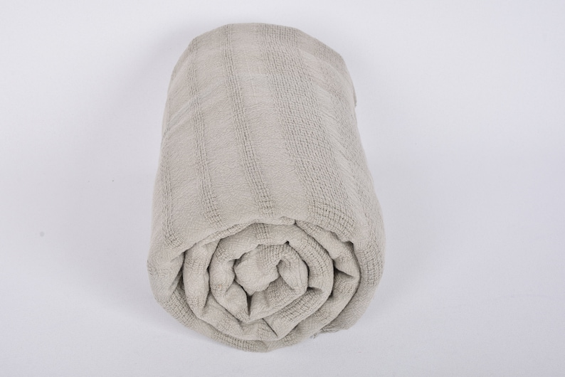 May include: A rolled up gray waffle weave throw blanket.