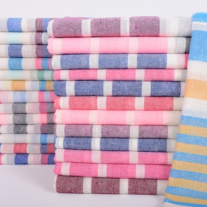 May include: A stack of striped towels in various colors, including pink, blue, and yellow. The towels are made of a soft, absorbent material and are perfect for drying off after a swim or shower.
