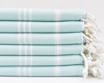 Può includere: Un mucchio di sei asciugamani di colore azzurro chiaro con strisce bianche e frange bianche.