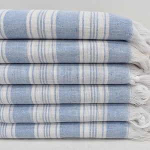May include: A stack of six blue and white striped towels with white fringe. The towels are folded neatly and are made of a soft, absorbent material.