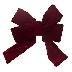 May include: A large, burgundy velvet bow with long, flowing tails. The bow is made of a soft, plush material and has a classic shape. The bow is perfect for decorating gifts, wreaths, or other crafts.