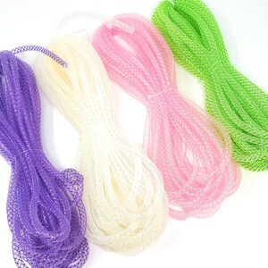 May include: Four spools of sparkly mesh ribbon in purple, white, pink, and green.